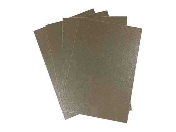 Stack of phlogopite mica sheets in amber gold, used for the outer high-strength layer of the thermal barrier board